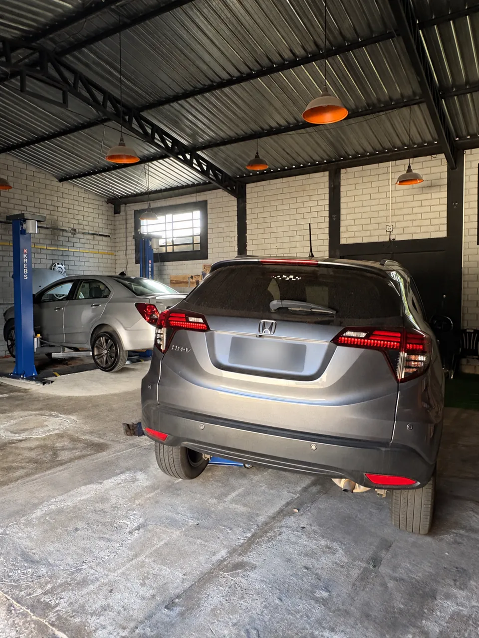 Honda na oficina, com placa ocultada